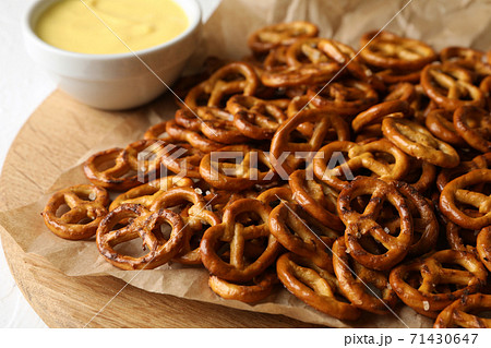 Tasty cracker pretzels and cheese sauce on white background 71430647