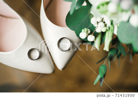 Beautiful toned picture with wedding rings and wedding shoes Beautiful toned picture with wedding rings and wedding shoes 71431930