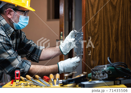 Carpenter at work protects the face with the surgical mask. Covid-19 prevention. 71435506