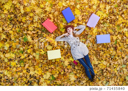 Woman dreams about shopping. Young woman lying on fall leaves next to shopping bags. Top view. Woman dreams about shopping. Young woman lying on fall leaves next to shopping bags. Top view. 71435840