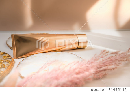 Golden cosmetic tube on pastel color minimalism beauty Golden cosmetic tube on pastel color minimalism beauty 71436112