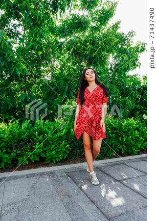 Beautiful fashionable brunette woman in red dress Beautiful fashionable brunette woman in red dress 71437490