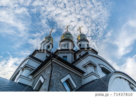three towers of the Orthodox Christian Church of St. Eugene with cupola domes and crosses in the village. Buky, Ukraine 71437810