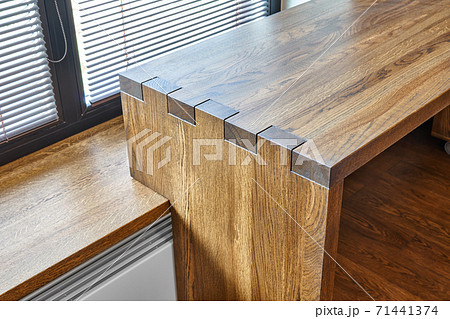Modern furniture. Box joint solid wooden desk against the background of the window 71441374