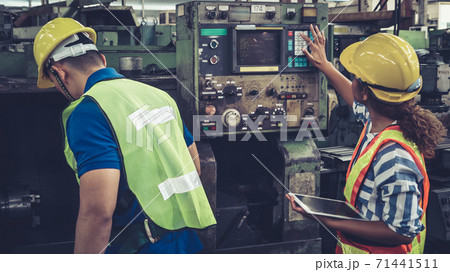 Group of factory workers using machine equipment in factory workshop Group of factory workers using machine equipment in factory workshop 71441511