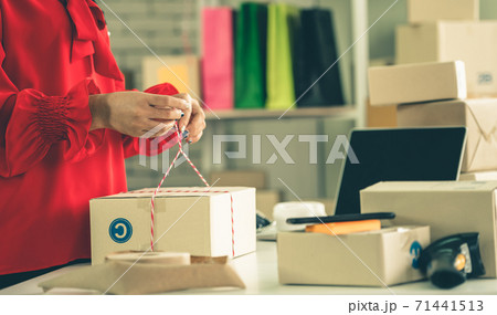 Online seller works at home office and packs shipping delivery box to customer. Online seller works at home office and packs shipping delivery box to customer. 71441513