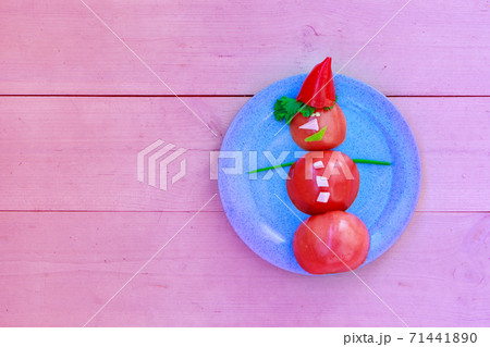 Snowman of tomatoes, peppers, ham and herbs on a plate. Christmas decor from food. Isolated on a pink background. Copy space Snowman of tomatoes, peppers, ham and herbs on a plate. Christmas decor from food. Isolated on a pink background. Copy space 71441890