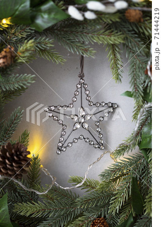 Christmas decorations, close up of silver star on Christmas wreath. 71444219