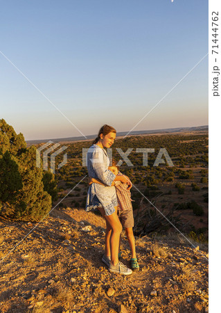 Teenage girl embracing her younger brother in the Galisteo Basin, Santa Fe 71444762