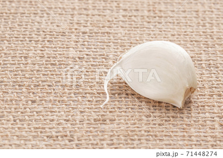 Garlic segment on wicker cloth made of natural materials, selective focus 71448274