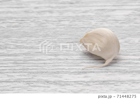 Garlic segment on a white wooden table, selective focus 71448275