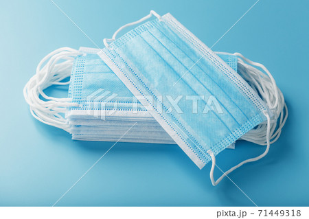 Stack of protective medical masks on a blue background, isolate. 71449318