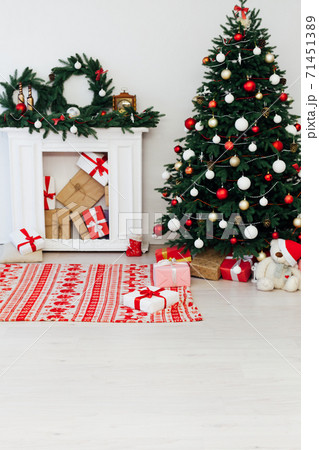 Christmas tree with gifts by the fireplace for the new year decor of the house Christmas tree with gifts by the fireplace for the new year decor of the house 71451389
