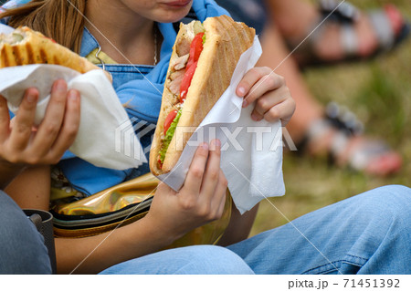 Crop girl eating sandwich in park Crop girl eating sandwich in park 71451392