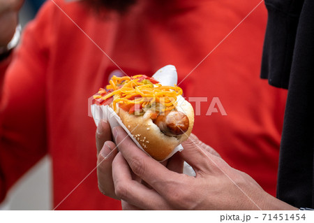 Crop man with hot dog in crowd 71451454