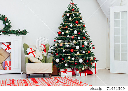 Christmas tree with gifts by the fireplace for the new year red decor of the house Christmas tree with gifts by the fireplace for the new year red decor of the house 71451509