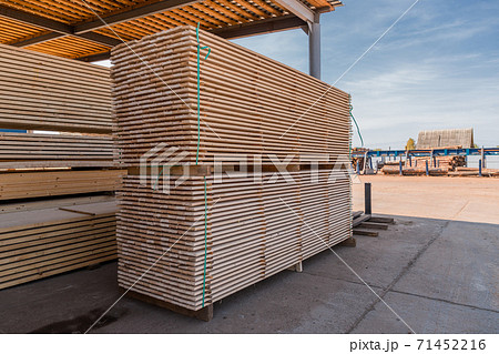 Piles of wooden boards in the sawmill, planking. Warehouse for sawing boards on a sawmill outdoors. Wood timber stack of wooden blanks construction material. Industry. 71452216