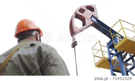 Silhouette of man engineer overseeing oil pumping unit in site of crude oil production. Industrial oil pump jack working and pumping crude oil for fossil fuel energy with drilling rig in oil field. Silhouette of man engineer overseeing oil pumping unit in site of crude oil production. Industrial oil pump jack working and pumping crude oil for fossil fuel energy with drilling rig in oil field. 71452329