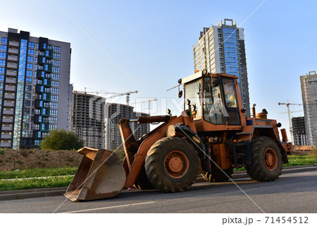 Wheel loader with a bucket on a street in the city during the construction of the road. Construction site  71454512