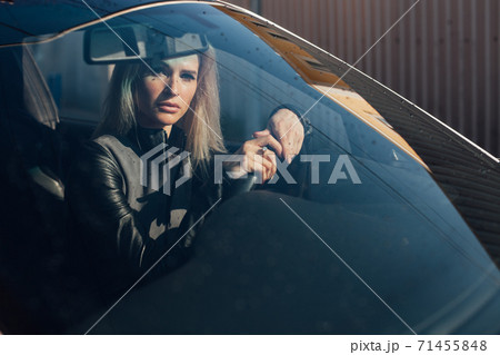 Beautiful blonde woman on the road driving a white car Beautiful blonde woman on the road driving a white car 71455848