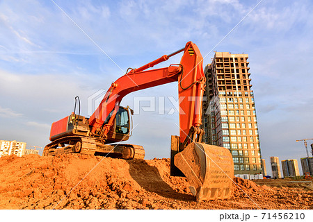 Excavator during excavation at construction site on sunset background.  71456210