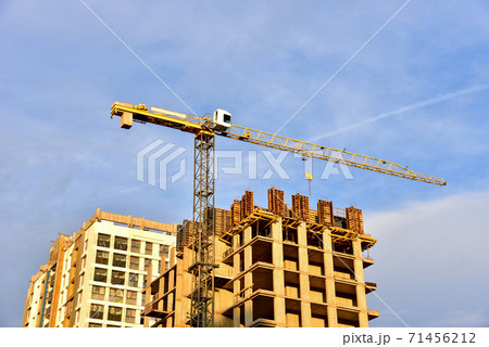 Tower cranes working at construction site on on sunset background. Tower cranes working at construction site on on sunset background. 71456212