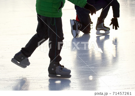 feet of different people skating on the ice rink feet of different people skating on the ice rink 71457261
