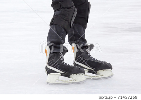 Legs of a man skating on an ice rink. Hobbies and sports. Vacations and winter activities Legs of a man skating on an ice rink. Hobbies and sports. Vacations and winter activities 71457269
