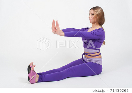Beautiful woman in purple leggings and top doing exercise for stretching on a white background Beautiful woman in purple leggings and top doing exercise for stretching on a white background 71459262