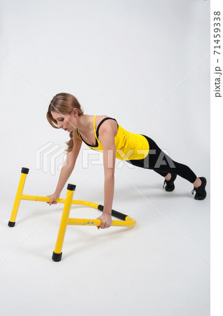 Woman doing exercises with high yellow floor bars on a white background 71459338