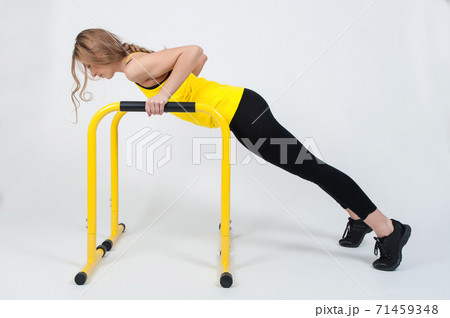 Woman doing exercises with high yellow floor bars on a white background 71459348