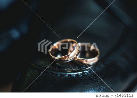Close up of wedding rings on a black leather shoe Close up of wedding rings on a black leather shoe 71461112