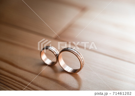 Pair of wedding golden rings on the yellow wooden Pair of wedding golden rings on the yellow wooden 71461202