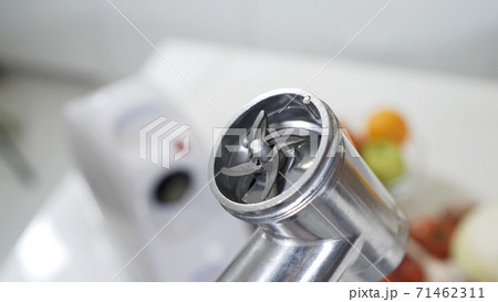 Female hand sets knife in meat grinder for providing high-quality mince from all types of meat. Electric mincer machine for minced meat per minute, make sausages, mashed berries, squeeze juice. Female hand sets knife in meat grinder for providing high-quality mince from all types of meat. Electric mincer machine for minced meat per minute, make sausages, mashed berries, squeeze juice. 71462311