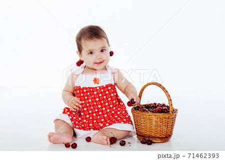 little girl with a basket of eating cherries 71462393