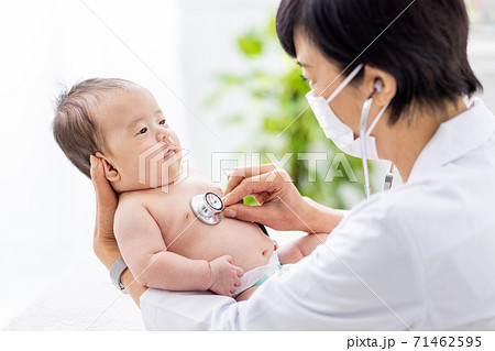 赤ちゃんを診察する女性医師の写真素材