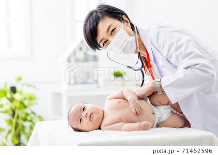 赤ちゃんを診察する女性医師の写真素材