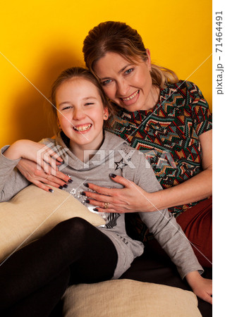 Mom and daughter sit on couch in family love room Mom and daughter sit on couch in family love room 71464491