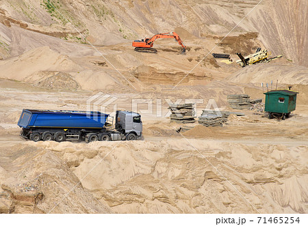 Truck with tipper semi trailer transported sand from quarry. Dump truck and excavator in open pit  71465254