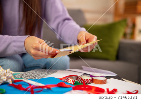 Woman making greeting card for New Year and Christmas 2021 for friends or family, scrap booking, DIY 71465331