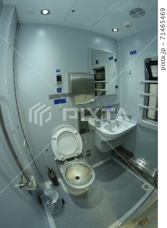 Toilet in Railways First Class sleeping carriage of a passenger train, toilet bowl, washbasin, mirrors and paper box 71465469