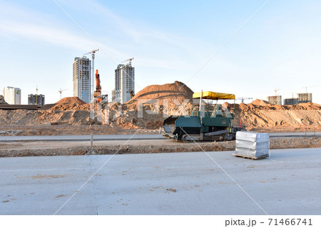 Paving roller machine and excavator during road work.  71466741