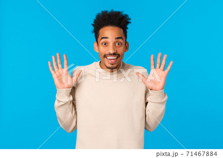 Hey no hands, I got nothing. Cheerful smiling handsome african american boyfriend fooling around, raising palms in surrender gesture, joking express positive emotions, winter concept, blue background Hey no hands, I got nothing. Cheerful smiling handsome african american boyfriend fooling around, raising palms in surrender gesture, joking express positive emotions, winter concept, blue background 71467884
