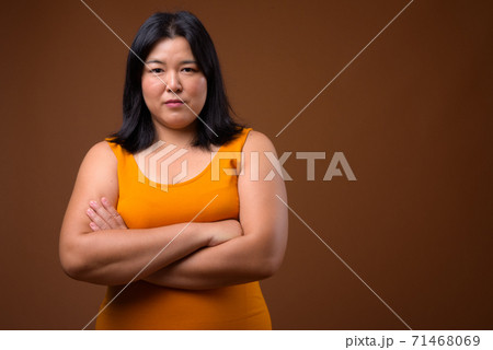 Portrait of beautiful overweight Asian woman with arms crossed 71468069