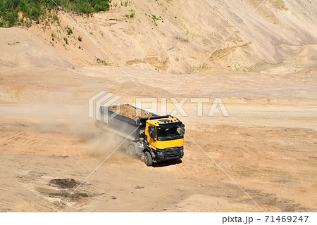 Dump truck transports sand in open pit mine 71469247