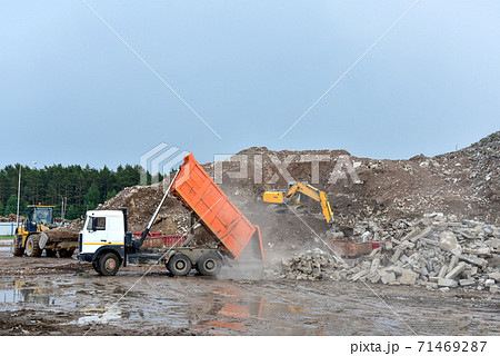 Dump truck unloading old concrete and asphalt from demolition for recycling. Dump truck unloading old concrete and asphalt from demolition for recycling. 71469287