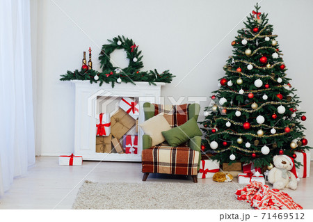 Christmas tree with fireplace interior of white room new year decoration garland gifts Christmas tree with fireplace interior of white room new year decoration garland gifts 71469512