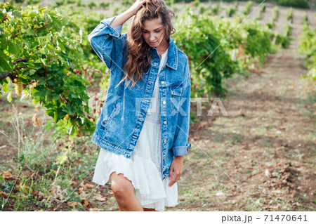 Beautiful woman collects grapes in a vineyard 71470641
