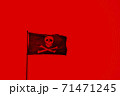 A red coloured pirate flag with with skull and bones 71471245