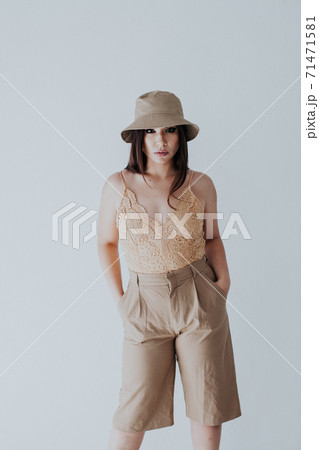 brunette woman of oriental appearance in beige clothes brunette woman of oriental appearance in beige clothes 71471581